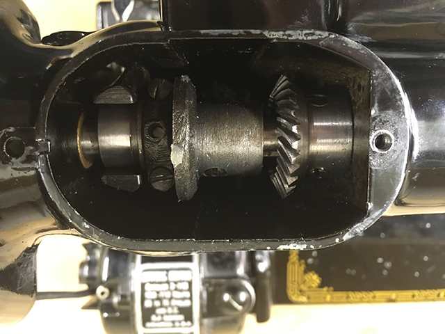 The spool pin cover has been removed and the upper helical gears are visible.