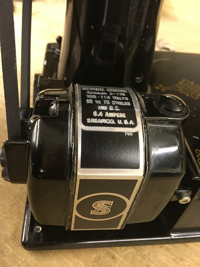 A closeup of the motor nameplate, which reads, "SEWING MOTOR / Catalog 3-110 / 100-110 Volts / 25 to 75 Cyces and D.C. / 0.4 Ampere / Simanco, U.S.A. / 700"