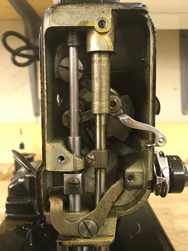A closeup of the needle mechanism. A portion of the thread tensioner is visible to the right.
