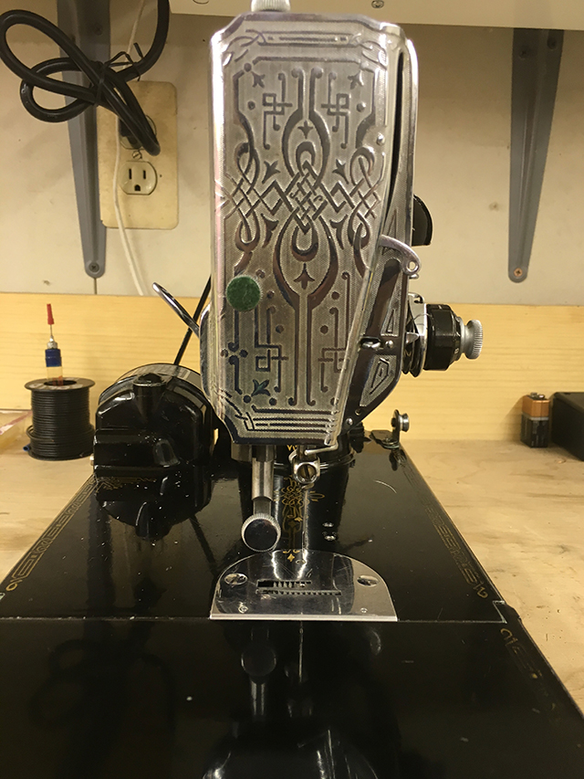 A closeup of the scrollwork on the chrome-plated cap that covers the needle mechanism.