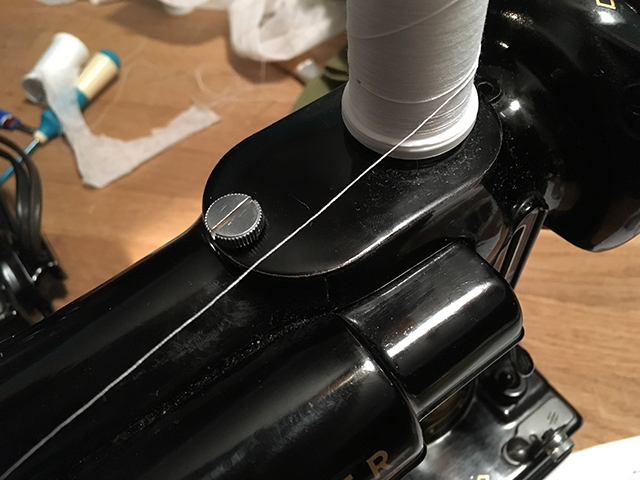 The flathead screw that holds on the spool pin cover has been replaced with a wide, flat thumbscrew.